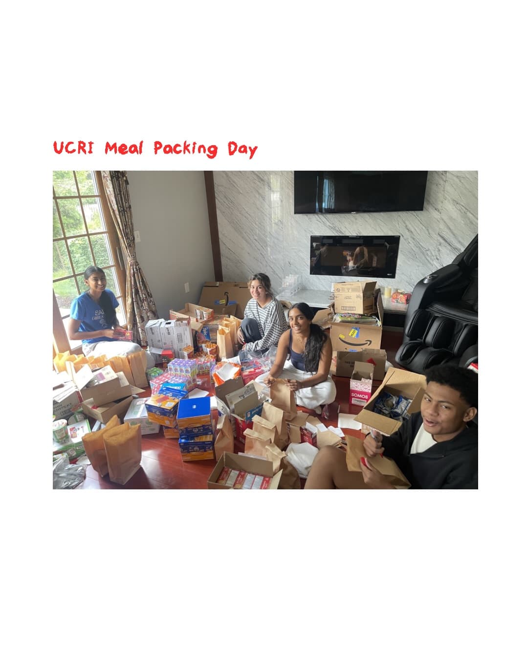 Four UCRI volunteers packing meals together around a table